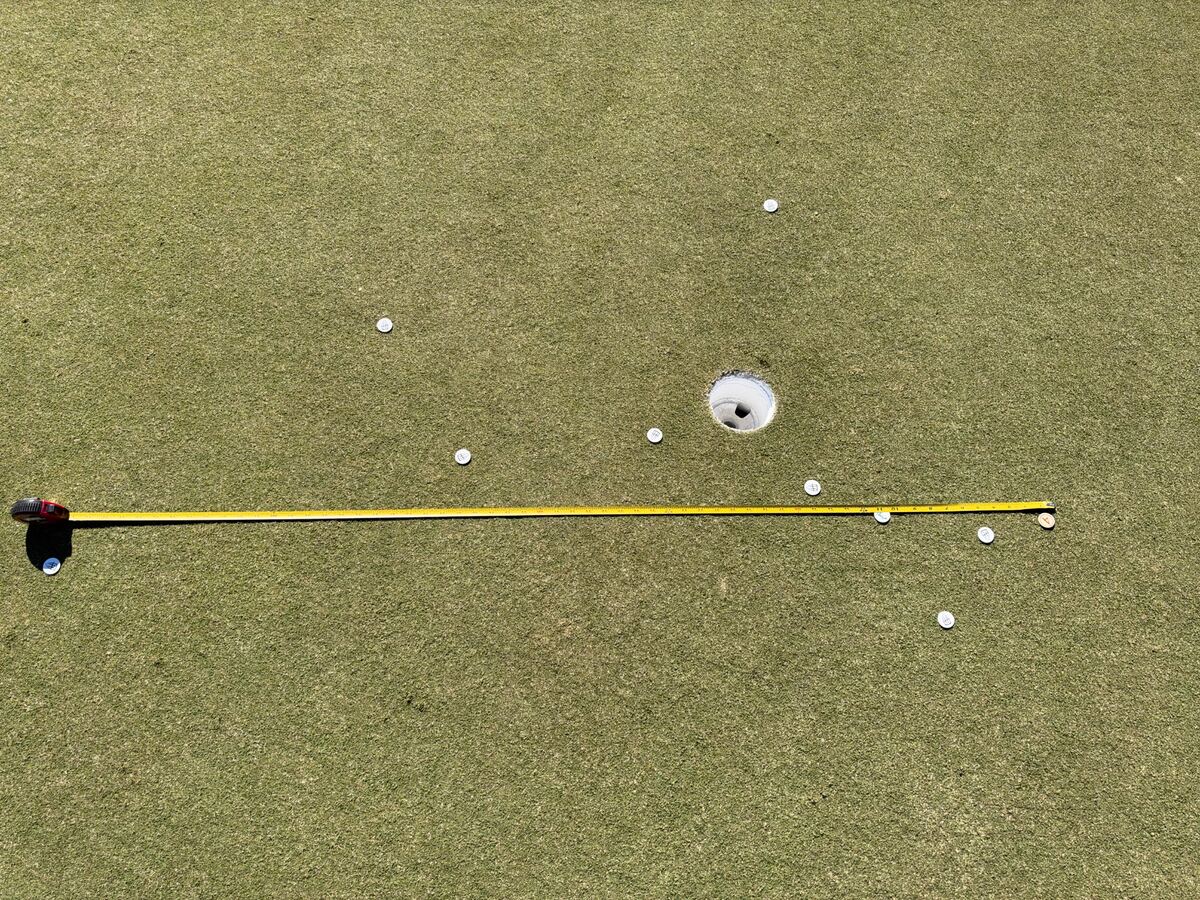 Tape measure laid across the green to measure one direction of putting dispersion