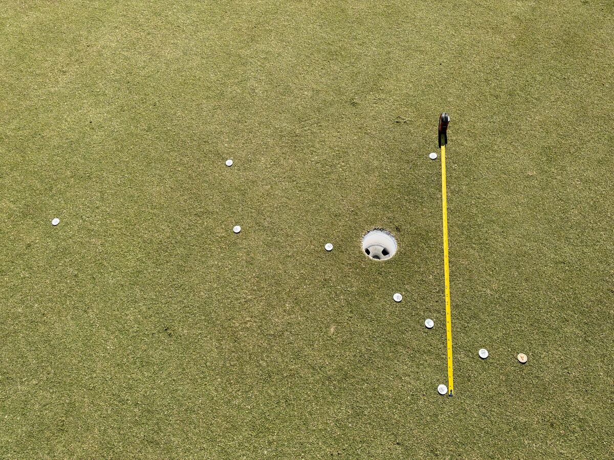 Tape measure aligned with the line of the putt to measure distance dispersion